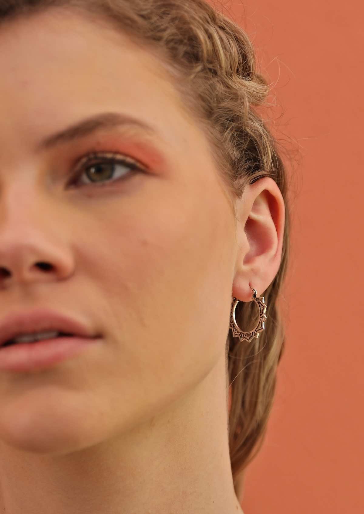 woman wearing silver boho decorative hoop style earrings