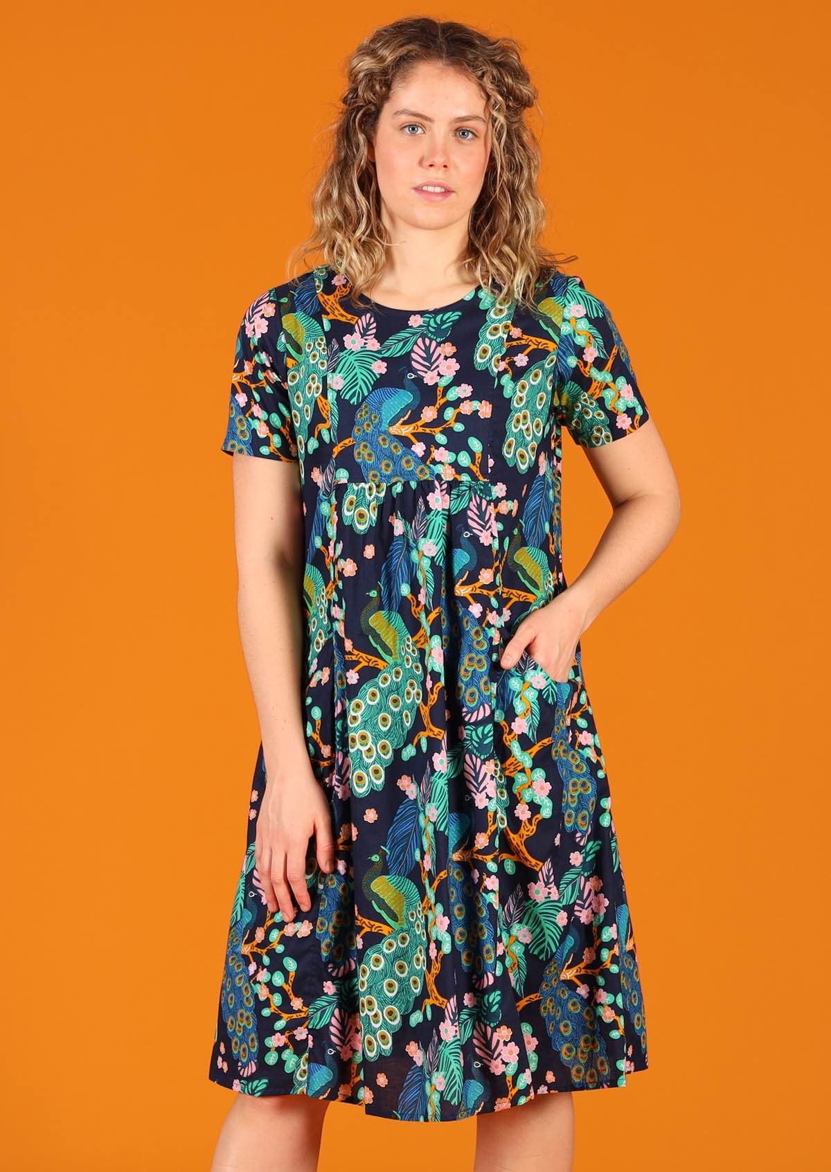 Model wearing peacock print lightweight cotton dress with pockets