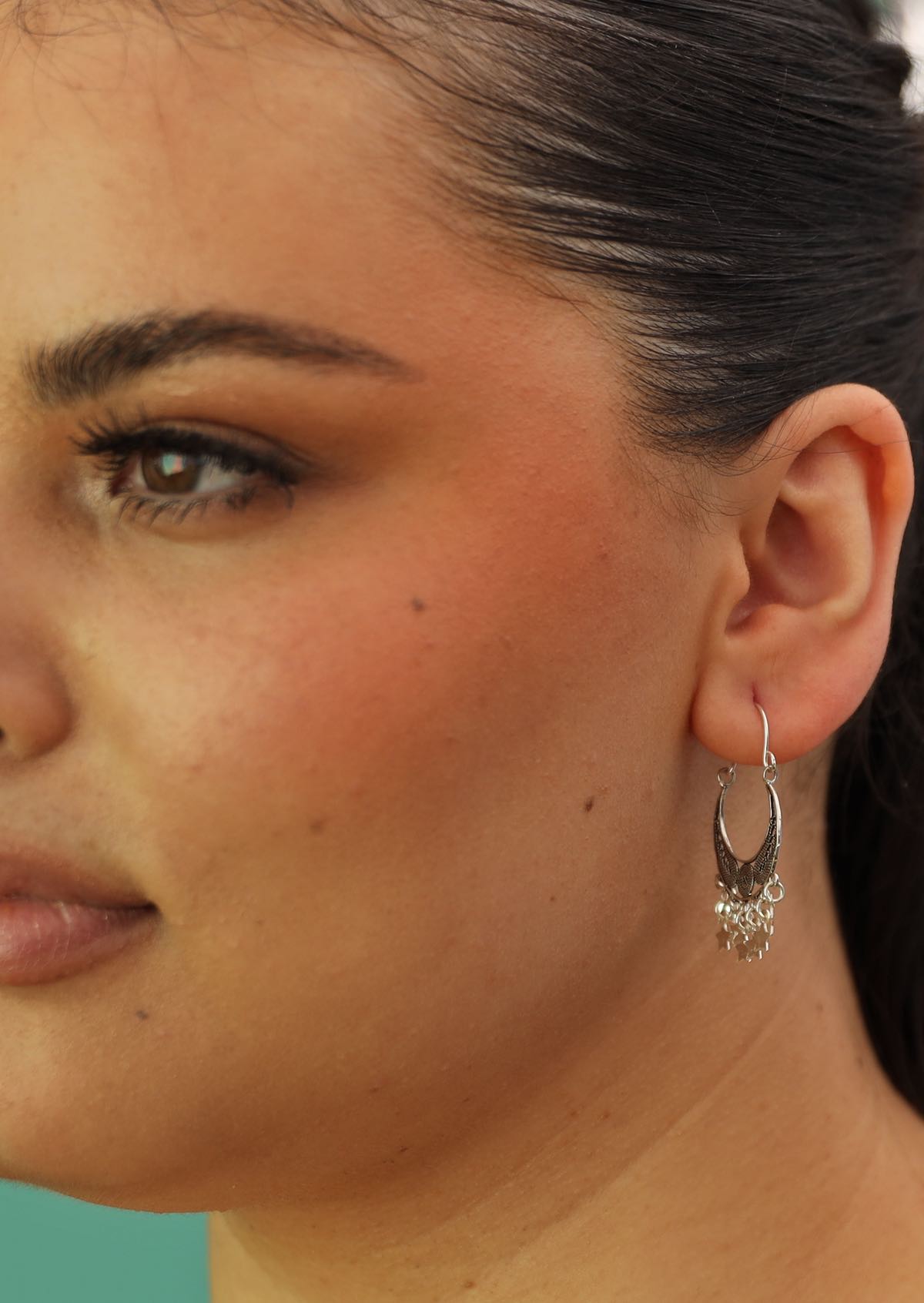 silver boho earrings with dangly stars and filigree on woman's ear