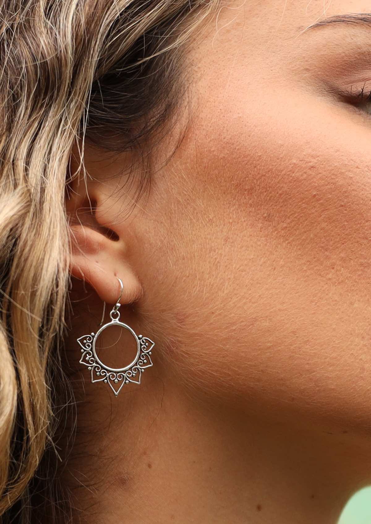 Close up of boho silver earring on woman