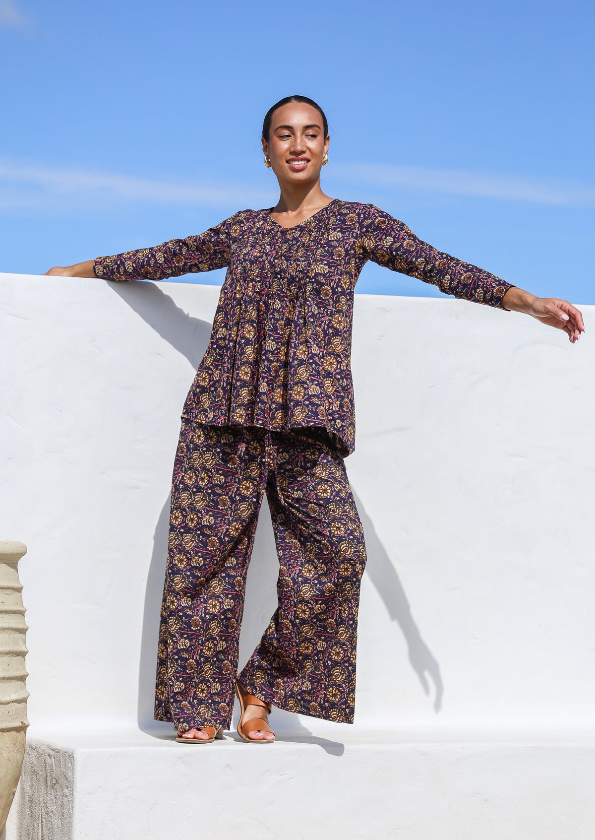 Model wears cotton long sleeve, button through top with wide leg, floral printed pants in the same pattern.