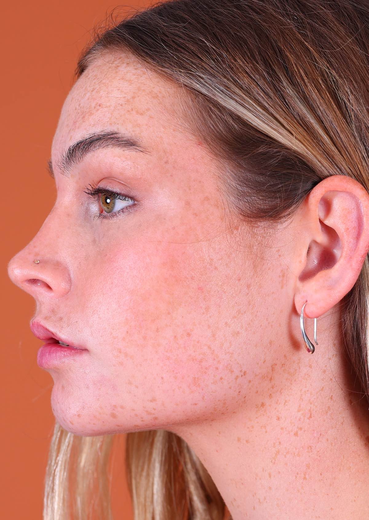 woman wearing silver drop earring