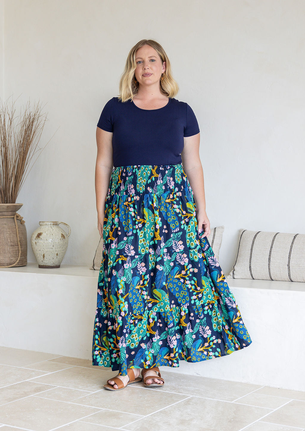 woman wearing a simple navy top and 100% cotton maxi skirt in navy based colourful floral print.