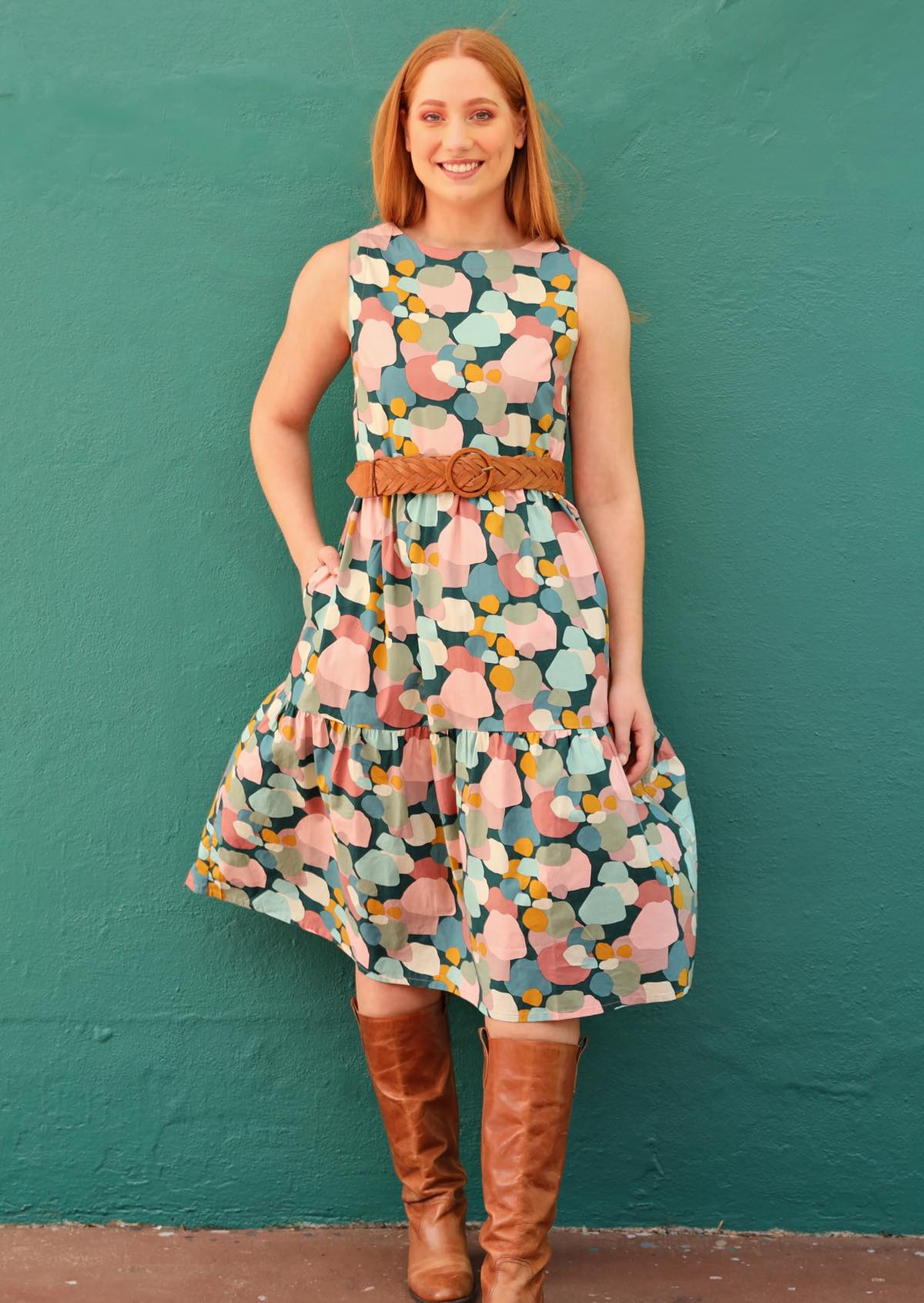 Red haired model in midi dress with pockets worn with belt and leather boots