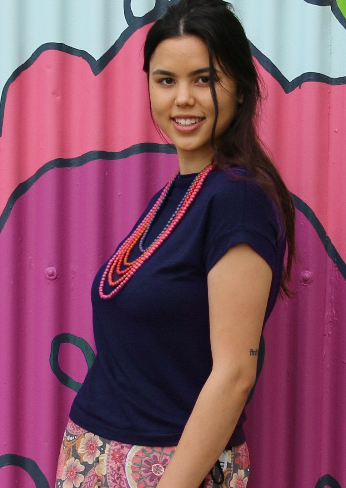 Woman with dark hair wearing a wide neck mod navy blue stretch rayon boat neck top