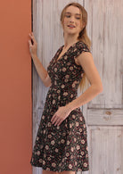 Woman posing in 100% cotton retro inspired dress with cross over bodice, cap sleeves and generous skirt