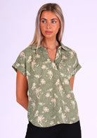 Woman wears cotton loose fit top with short sleeves with a rolled cuff, a V-neckline and a collar