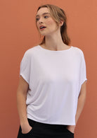 Woman wears white stretch rayon batwing t-shirt paired with black pants