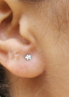 Delicate sterling silver dainty flower studs with soft, polished petals and bloom design 