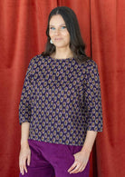 Model wears relaxed fit cotton top with 3/4 sleeves and round neckline in dark purple based floral print.