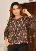 Model poses in relaxed fit top with 3/4sleeves in beautiful black based indian floral print.
