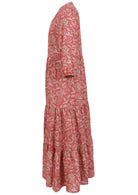 Side view of a full length maxi dress with 3 tiered flowy skirt, mandarin collar, buttoned bodice and pockets