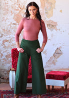 olive green wide leg corduroy pants on woman with pink top and dark hair 