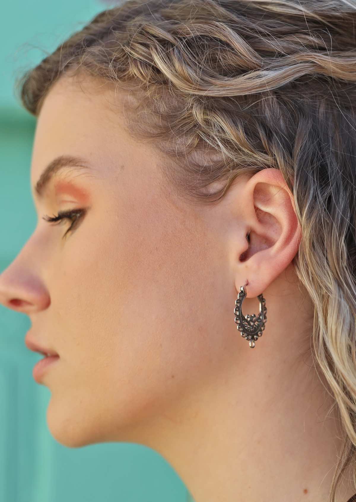 model wearing ornate boho silver hoop earrings