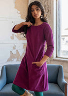 Woman wearing 100% cotton 3/4 sleeve corduroy shift dress with one hand in pocket