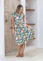 Woman wearing a pastel print cotton day dress with a waist tie and buttoned bodice | Katie Dress Sweet Spot