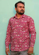 Man wears cotton long sleeve Indian floral print shirt with coconut buttons and a collar