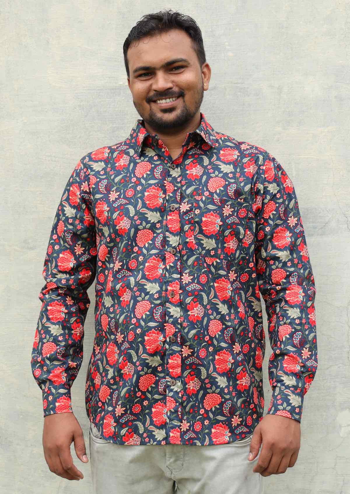 Man wearing a floral print collared shirt with long sleeves and one breast pocket