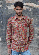 Man wears cotton long sleeve collared shirt with coconut buttons and one breast pocket