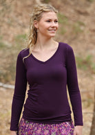woman wearing long sleeve dark purple top with v neck 