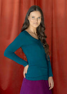 Woman wearing a teal long sleeve stretch v-neck soft rayon top