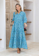 Model in 3/4 sleeves, relaxed fit tiered maxi dress in aqua based floral print.