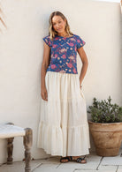 Model wearing a plain white cotton skirt with elasticated and drawstring waistband.