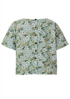 Back view of pale sage green based daisy floral print cotton relaxed fit short sleeved top with decorative buttons through the centre back