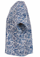 Side view of white based blue floral print cotton relaxed fit short sleeved top with round neckline