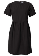Loose fitting above knee length plain black cotton dress with short sleeves, high round neckline and pockets