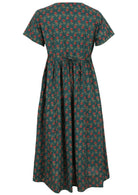Back view of green based motif in red, pink, green, and mustard floral print V-neck cotton dress with pockets.