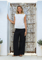 Woman wears cotton sleeveless top in plain white colour with gathers under the square neckline yoke