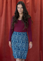 Model wearing blue, floral printed reversible skirt with hidden side zipper.