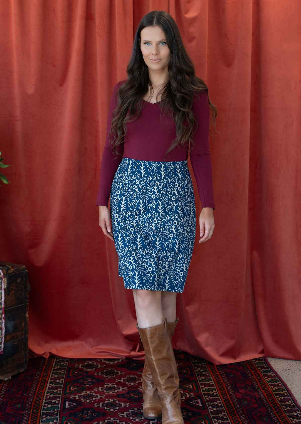 Model wearing knee length, cotton reversible skirt with white florals on blue base.