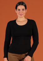 Woman wearing a round neck black long sleeve rayon top.