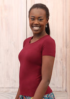 Woman with dark hair wearing a scoop neck maroon rayon fitted t-shirt.