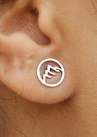 Close up of a sterling silver circular Alps studs with delicate mountain cutout details 