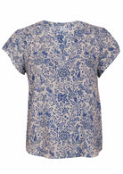 White based blue floral print cotton top with V-neckline on a white background.