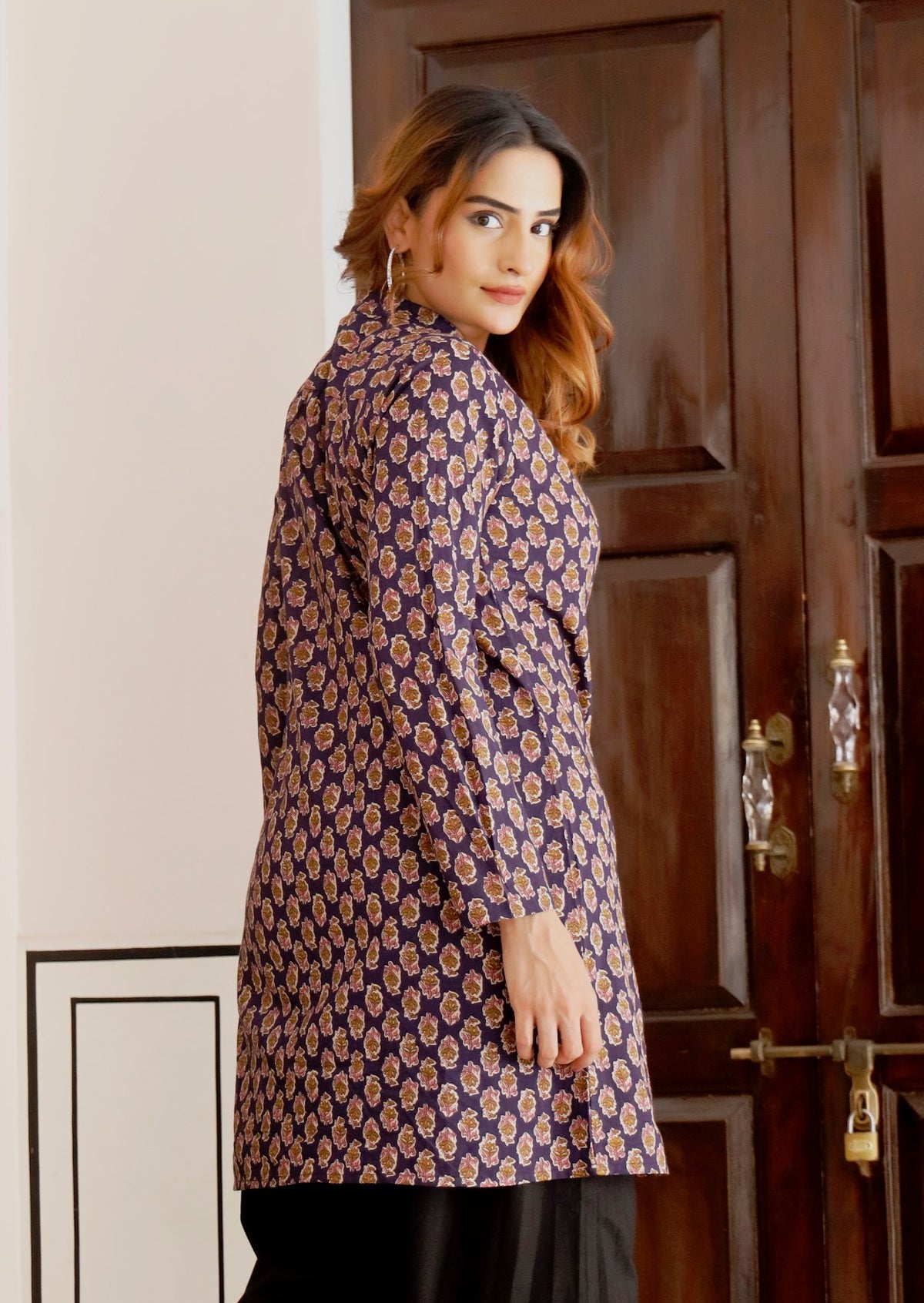Woman stands in A line cotton tunic with buttoned bodice, mandarin collar and V neckline.