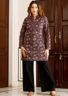 Model poses in long sleeve cotton tunic with V-neckline, buttons and mandarin collar, in purple based floral print.