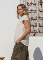 Model wearing 100 percent cotton short sleeve pleated top paired with olive green pants
