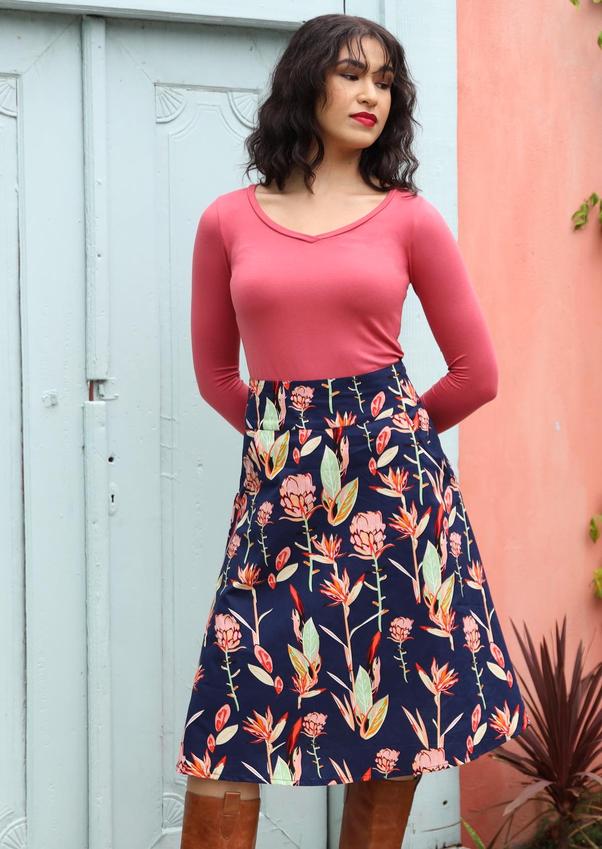 Zarah Skirt, wide waistband below the knee length wide a-line cut side pockets side zipper 100% cotton with navy background native botanic print | Karma East Australia