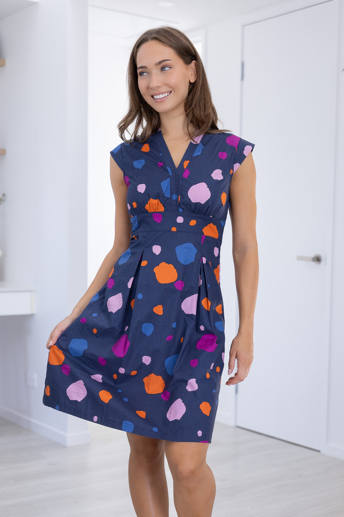 Model poses in V-neck Knee Length retro inspired Dress with cap sleeves and structured bodice