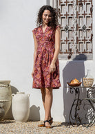 Woman wearing Japanese style floral print cotton dress with cap sleeves, box pleats and V neckline