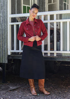 woman wears cotton corduroy jacket over black corduroy skirt 