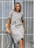 Woman wearing a cotton Floral print short-sleeve shift dress in dune tones. 