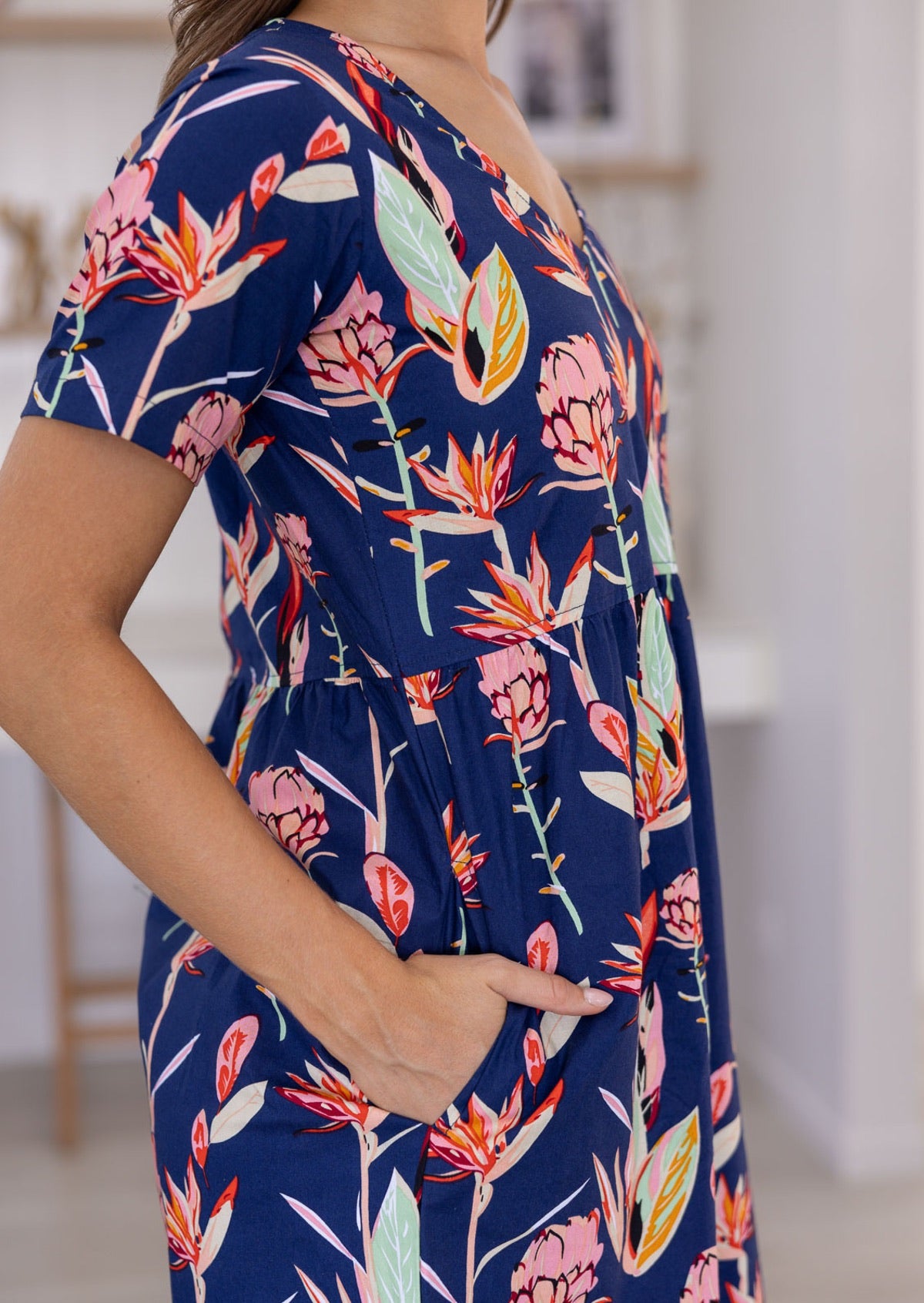 Close up picture of woman wearing a 100% cotton bold botanic printed dress 