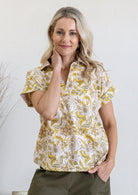 Woman poses in relaxed fit cotton short sleeve top with rolled cuffs sleeves, collar and V neckline.