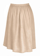 Nude toned slight A-line cotton slip skirt with elasticated waist and picot trim on hem, side view