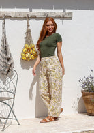 Woman is wearing a 100% cotton cream floral-print wide-leg pants with olive green t-shirt. 